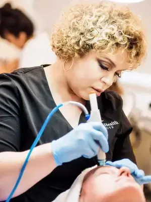 beauty and health institute professional stylist is seen working on a womans hair